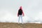 Tween girl with backpack looking on beautiful mountains in clouds, family travel concept