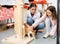 Tween girl and female volunteer playing with ginger cat in animal shelter