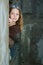 Tween girl peeking around a wall