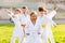 Tween girls and boys exercising taekwondo techniques on green lawn