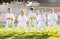 Tween girls and boys exercising taekwondo techniques on green lawn