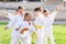 Tween girls and boys exercising taekwondo techniques on green lawn