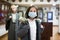 Tween schoolgirl in medical mask observing arts and crafts in gallery