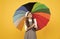 tween with vivid rain protection. happy school girl in glasses. teen child under colorful parasol
