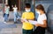 Tweenage schoolchildren in masks talking near school building