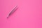 Tweezers stainless steel for women on pink background. Silver pincers for eyebrow plucking