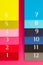 Twelve different color diaries on a pink wooden desk