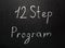 Twelve step program written in white chalk on a black chalkboard