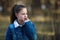 Twelve-year-old girl in a denim jacket posing in a pine Park