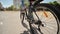 A twelve-year-old girl riding her bike on a warm summer day. Bicycle wheel close up.