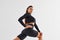 Twerk dancing. Sportive woman in black clothes in the studio against white background