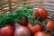 Twig with tomatoes, onions, and rosemary in a wicker basket.