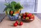 Twigs with strawberries in a ceramic vase and in a wooden bowl strawberries, a few strawberries lie side by side