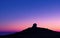 Twilight descends as a starry sky emerges above a solitary observatory on a hill, portraying peace and scientific