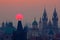 Twilight in historical city. Magical picture of tower with orange sun in Prague, Czech Republic, Europe. Beautiful detailed sunris