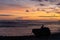 Twilight Meditation A solitary figure sits on a rock by the sea, meditating as the day ends with a beautiful display of sunset