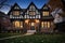 twilight shot of tudor home featuring the well-lit brick base