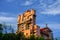 The Twilight zone Tower of Terror and palm trees on lightblue cloudy sky background in Hollywood Studios at Walt Disney World .