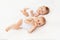 Twin babies boy and girl with a bottle of milk on a white bed at home, baby food concept, place for text