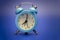 Twin bell analog alarm clock over blue background