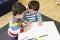 Twin boys drawing at a table together