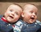 Twin boys in overalls smiling