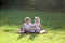 Twin children sit in a city park on a summer day