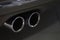 Twin chrome tailpipe of powerful sports car with black body and gray plastic parts