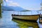 A twin-engine wooden boat with a roof on a cristal clear lake.