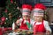 Twin girls in red making Christmas cookies