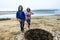 Twin girls standing on remains of ancient roman water well