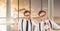 Twin hipster men holding clocks in airport