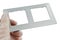 Twin light switch frame made of design plastic material looking like aluminium, held in hand with safety latex glove