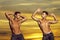 Twin men, handsome young male athletes show sexy, muscular torso with six packs abs outdoors. Handsome confident young