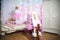 Twin sisters dressed as dogs in a children`s room decorated for Christmas. The sister is riding a horse in the room, the siste