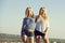 Twin sisters, girls, posing on blue sky