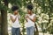 Twin sisters holding a cups with drinks and looking on each other