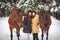 Twin sisters and horse in the winter forest