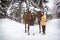 Twin sisters and horse in the winter forest