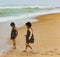 Twin Sisters indian kids running on puri sandy beach in seashore expressing joy