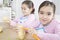 Twin Sisters Peeling Potatoes in Kitchen