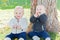 Twin Toddlers Sitting Near Tree Trunk