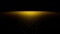 Twinkling golden glitter on a flat surface in front of a black background lit by a bright spotlight