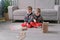 Twins boys brothers are building from wooden blocks sitting on the floor by the sofa in their room.