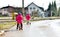 Twins children riding balance bikes on the road with helmet.