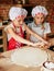 Twins little chefs enjoying in the kitchen making cakes. Girls at the kitchen. Family housekeeping