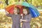 Twins looking for shelter with umbrella