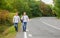 Twins walk along road. Brothers friends nature background. Long way. Adventure concept. Guys hitchhiking on road