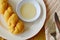 Twist bread dipping with sweetened condensed milk on plate