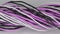 Twisted black, white and purple cables and wires on white surface